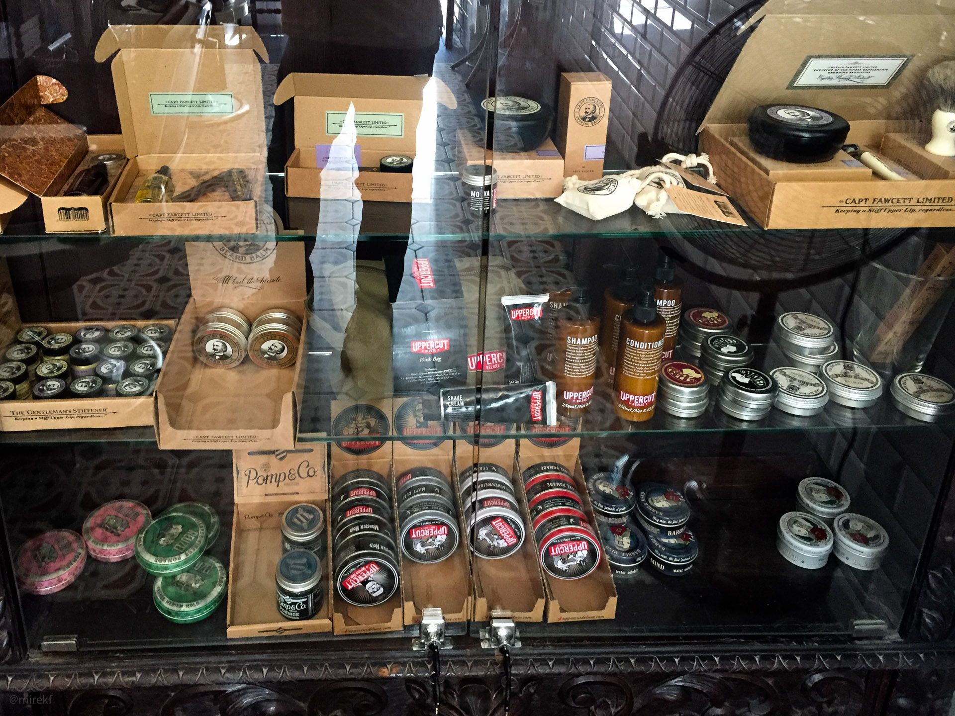 Wnętrze salonu Rostowski Barber Shop – witryna z kosmetykami do sprzedaży